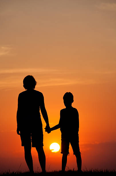 mulher e criança assistindo o pôr do sol de verão - standing family golf loving - fotografias e filmes do acervo