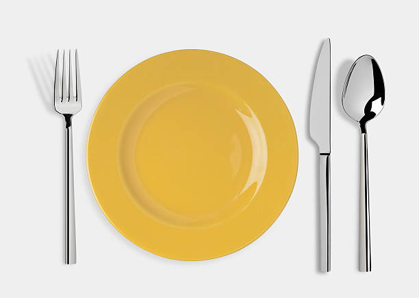 Empty plate with Knife, Spoon and Fork Empty yellow plate and fork,spoon and table knife isolated on white background. Include clipping path. plate and fork stock pictures, royalty-free photos & images