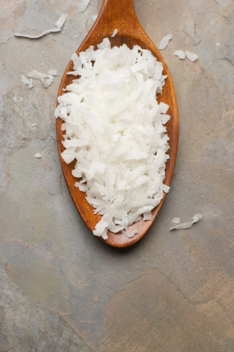 Coconut flakes in wooden spoon with copy space.