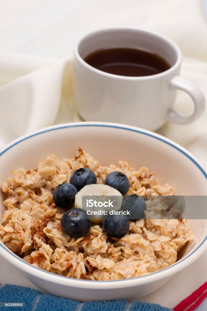 Breakfast Oatmeal with Fruit Breakfast hot oatmeal cereal with blueberries and banana.  Cup of coffee in background. Banana Stock Photo