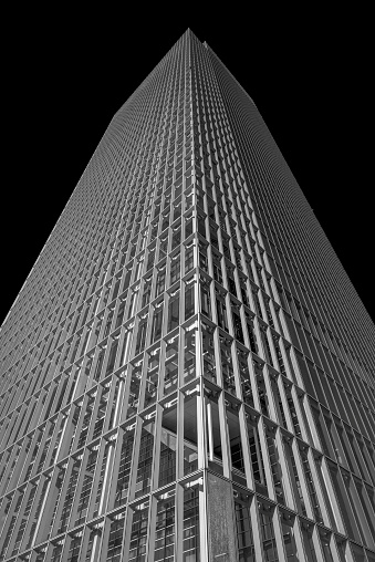 Turin, Piedmont, Italy - August 06, 2023. Skyscraper in the Piedmont region taken from below, in black and white, with a black sky. Architectures of one of the tallest and most recent buildings in the city of Turin.