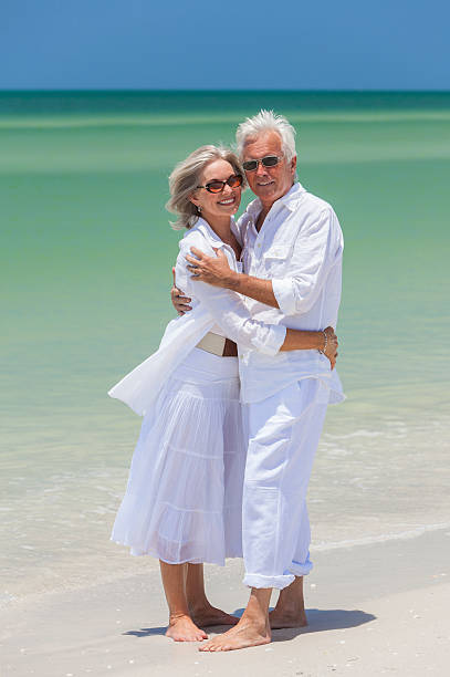 istock Happy Senior Couple Embracing on Tropical Beach 162258679