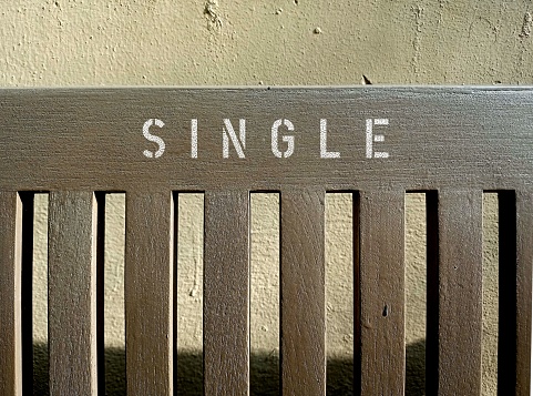 Banco de madera con inscripción textual SINGLE, concepto de persona individual, estar solo, soltero o no involucrado en una relación sexual estable. photo