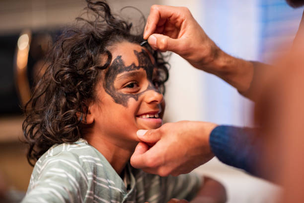 Beautiful little kid boy with face painted with animal or cat, on a birthday party. happy child having fun. Activity for kids on birthday celebration part, face painting, fun and happiness