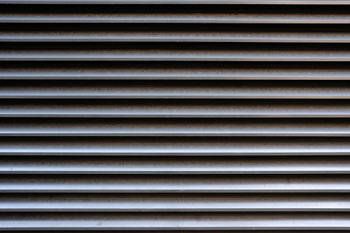 Close-up on gray metal vents to allow the passing of air.