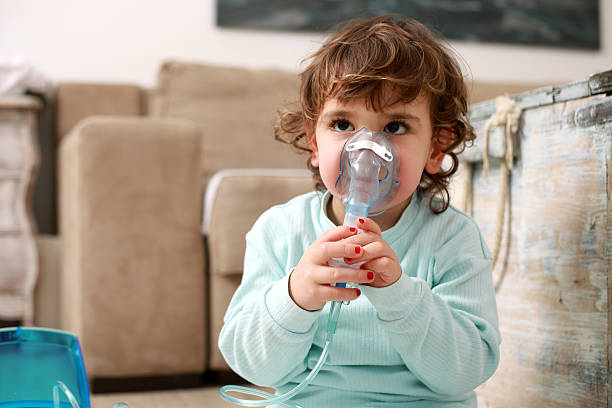 asma, poco chica con máscara de inhalación - tubing child oxygen mask medical oxygen equipment fotografías e imágenes de stock