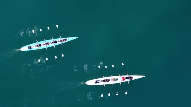 Aerial drone bird's eye view video of two sport canoe operated by team of young men and women