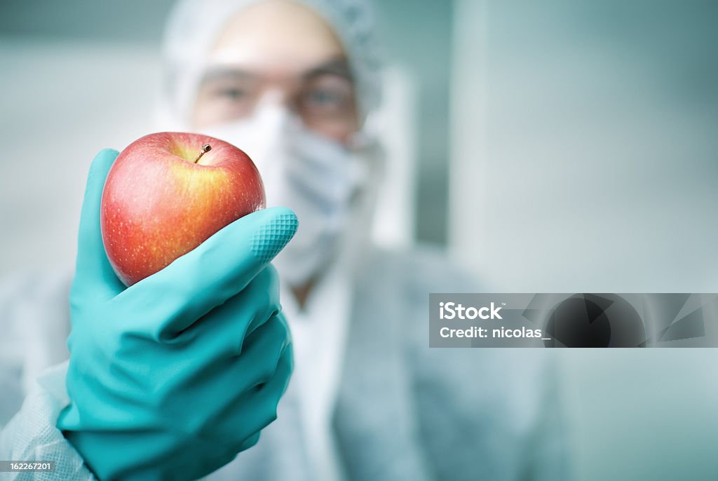 Lab Worker Holding Apple A lab worker holding an apple  Apple - Fruit Stock Photo
