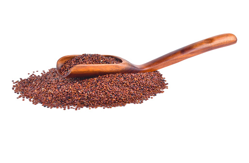 red quinoa seeds in wooden spoon isolated on white background.
