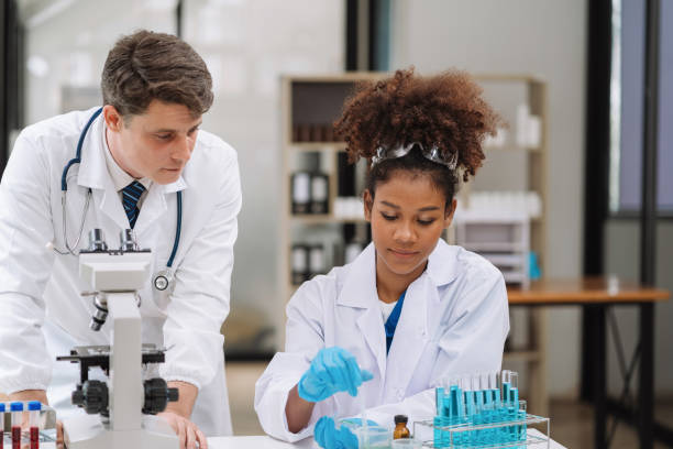 istock Team of biochemical research scientists working with a microscope for vaccine development in pharmaceutical research labeling. 1622680767