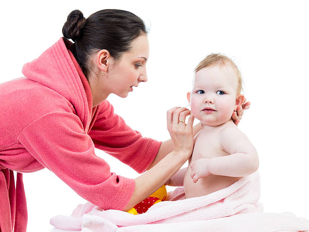 mãe limpeza ouvidos seu bebê após o banho - solicitous imagens e fotografias de stock