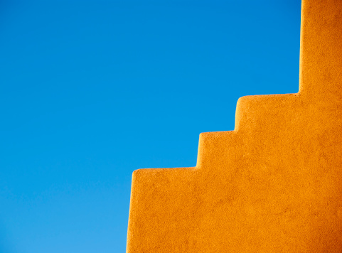 Part of an Adobe skyle house and blue sky. Taken at Albuquerque and Santa Fe area, in New Mexico, USA.