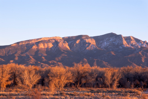 The Sandia Mountains viewed from east, receiving the light from sunset in fall. The Sandia Mountains stand widely east of Albuquerque, New Mexico, USA.