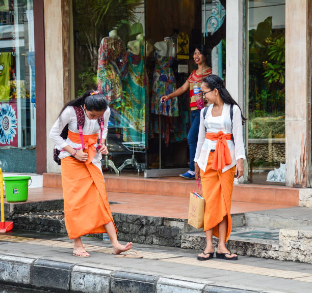 Bali, Indonesia - Apr 21, 2016. Young women walking on street in Bali, Indonesia. Bali is a popular tourist destination, which has seen a significant rise in tourists.