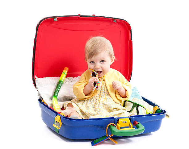 istock baby girl seated in a suitcase on white 162271898