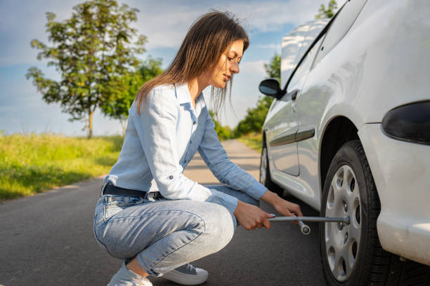 istock A young woman performs repairs with a car tire jack on the road 1622723413