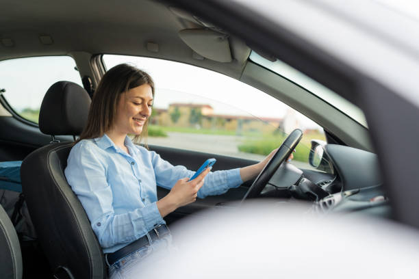 istock A young woman engaged with her phone while driving 1622725043