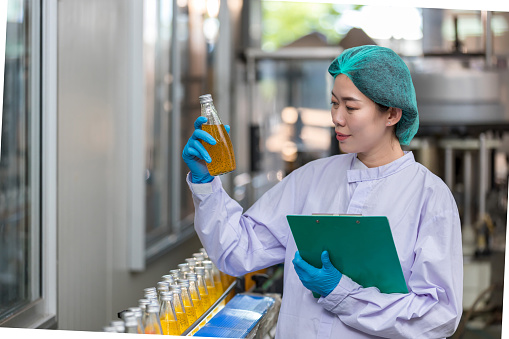 Food factory. Factory inspector controlling production. supervisor or worker using Checking quality or checking stock of products in beverage factory. Worker QC working in a drink water factory