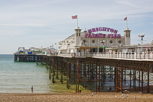 Brighton Palace Pier in East Sussex, England. With people on beach and pier.