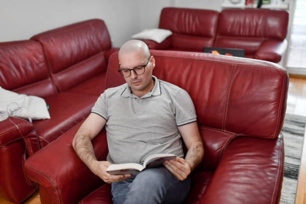 Male Cancer Patient Reading About His Illness And Treatment Methods