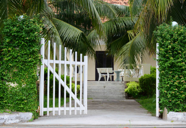 istock White picket fence with green trees at sunny day 1622770320