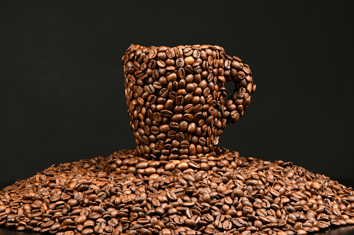 Cup of coffee made from roasted coffee beans. Coffee beans are glued into the shape of a cup. High resolution photo. Full depth of field.
