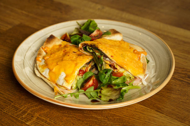 istock Ham and cheese tortilla sandwich with vegetables on a wooden table 1622776829