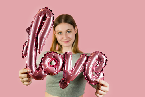 Closeup of love shaped balloon in hands of beautiful female. St Valentine's concept.Romance