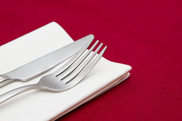 istock Knife and fork with white napkin on red tablecloth 162280229