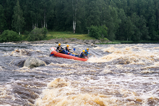 Karelia, Russia - July 28, 2023: team on a raft passes the rapids on the Shuya River