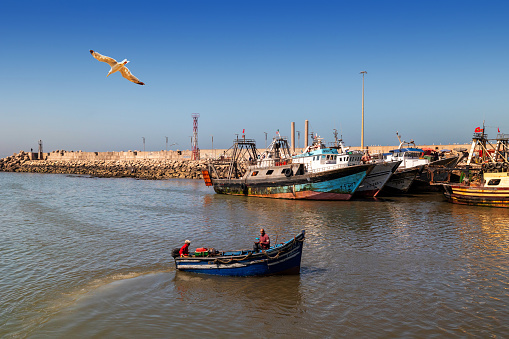 Essaouira, Morocco - August 2, 2023: A small boat returns to the port after sea fishing.