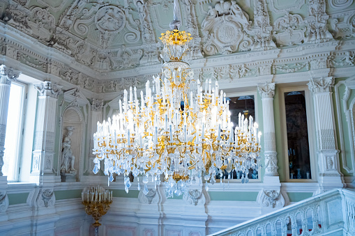 Chandelier of main staircase of Yusupov Palace. crystal three-tier chandelier lamp and luxury interior. front view. St. Petersburg, Russia 05.17.2023
