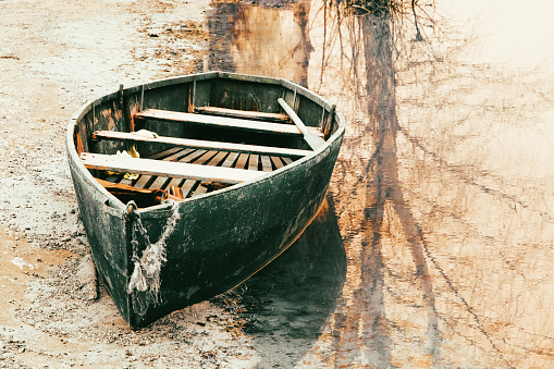 A beautiful and colorful rowing boat. The old rowboat moored on the shore. Toned image