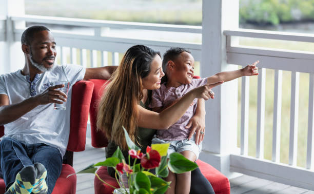 Multiracial family with young boy watching from porch