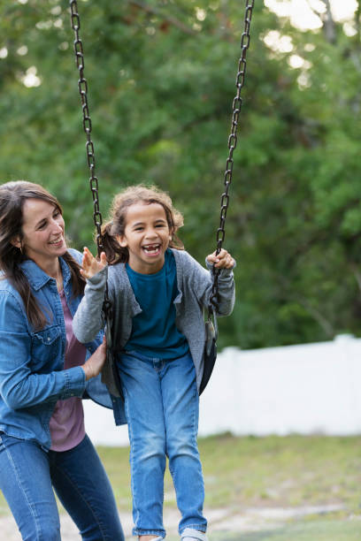 istock Mother pushing daughter on swing on playground 1622882617