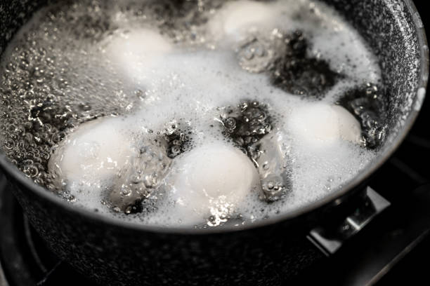 Chicken eggs are boiled in a steel pot on the built-in cooker. Boiled egg