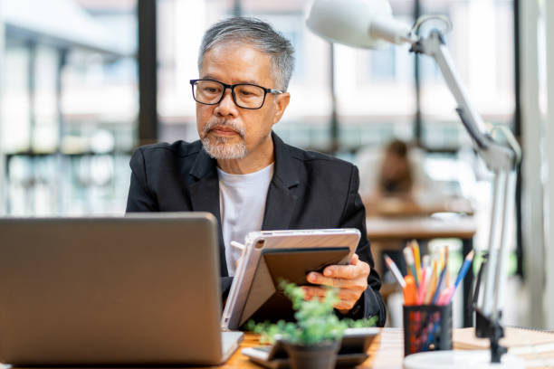 istock Middle aged male business executive sitting at his office desk working on his projects on his computer tablet 1622936544