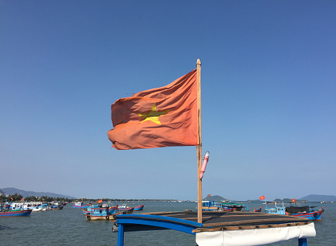 Vietnam flag on a fly bridge of a wooden fishing boat.