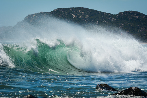 Big waves on South China Sea with mountain background in Khanh Hoa, Vietnam.