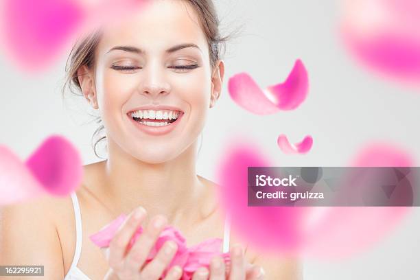 Junge Schöne Lächelnde Frau Mit Fliegenden Rosa Rosenblüten Stockfoto und mehr Bilder von Frauen