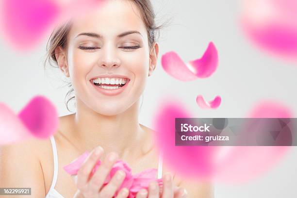 Jovem Bela Mulher Sorridente Rodeada Por Pétalas De Rosa Cor De Rosa Voador - Fotografias de stock e mais imagens de Face Humana