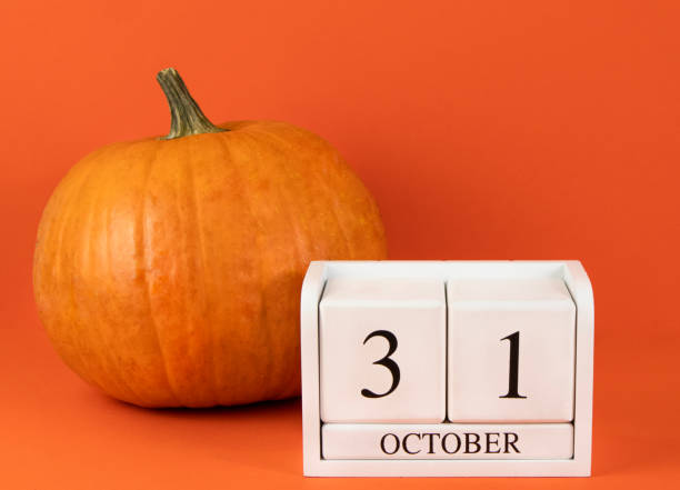 istock Halloween October 31 calendar and pumpkin on orange background. 1622964182