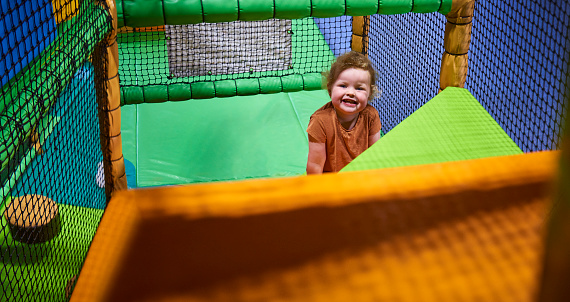 A little girl having fun playing at an indoor softlay