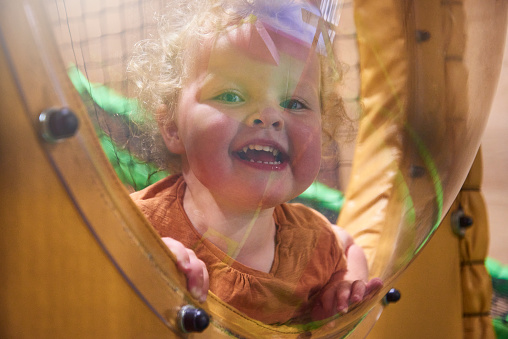 A little girl having fun playing at an indoor softlay