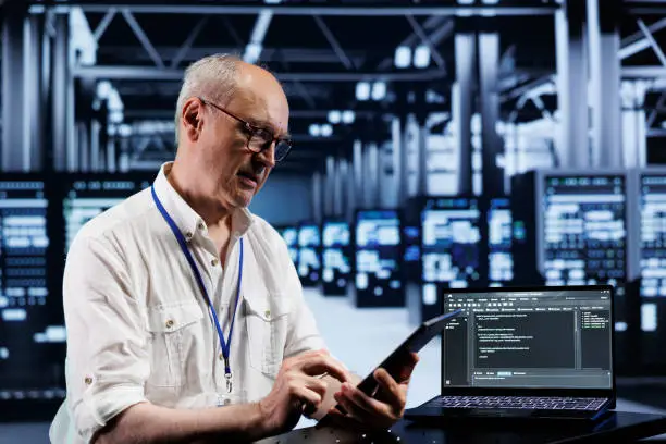 Photo of Senior engineer coding in data center