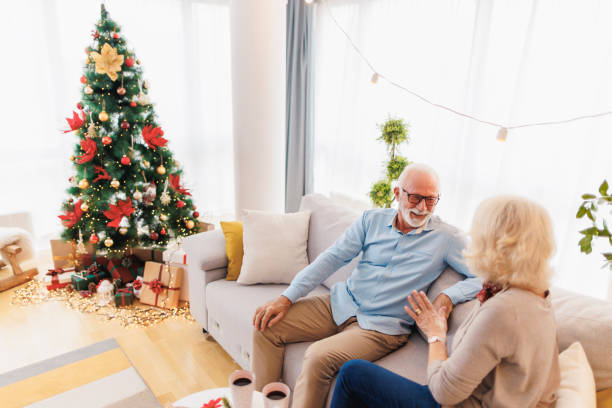 seniorenpaar trinkt am weihnachtsmorgen zu hause kaffee - communication discussion coffee christmas stock-fotos und bilder