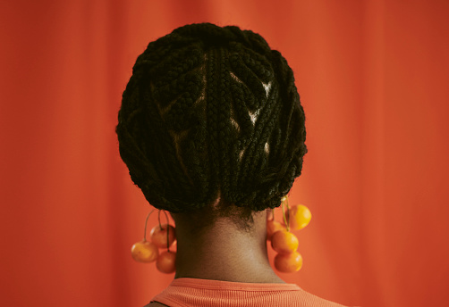 Black woman standing with her back towards the camera showing her beautiful braided hair. stock photo.