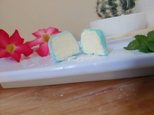 白い皿にバニラ餅アイスクリームのスライス、箸と木製の背景