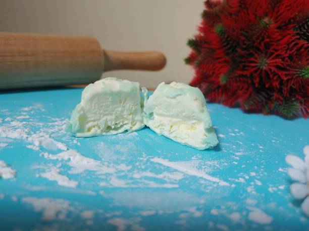 バニラ餅のアイスクリームをスライスし、小麦粉を振りかけ、麺棒を背景にした青いマテ茶の上のバニラ餅