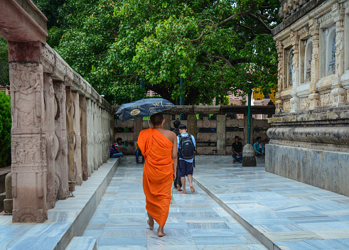 Bodhgaya, India - Jul 9, 2015. A monk walking at Mahabodhi Temple in Bodhgaya, India. Bodh Gaya is considered one of the most important Buddhist pilgrimage sites.
